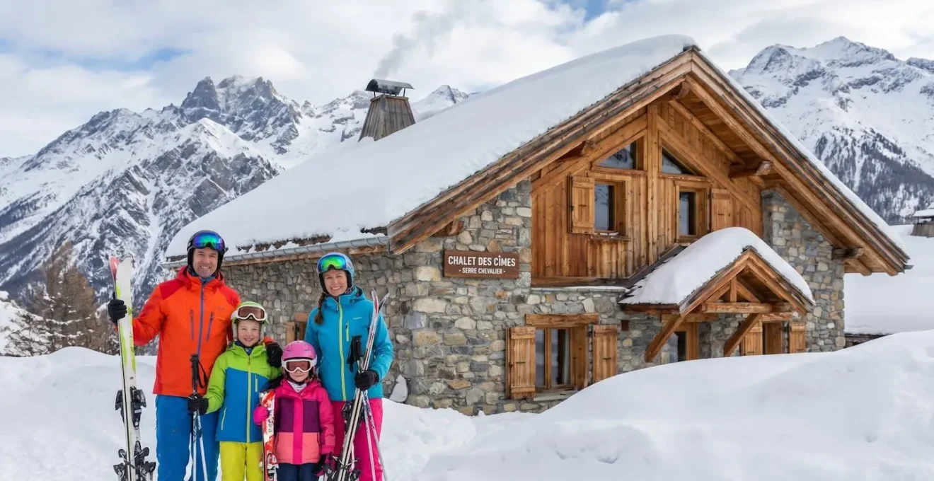 Famille en tenue de ski devant une résidence en station de montagne enneigée dans les Hautes-Alpes